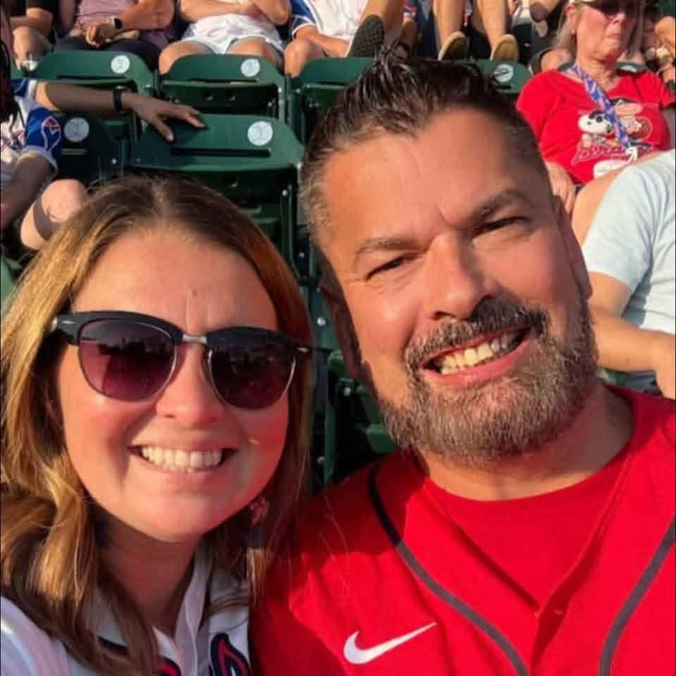 Tabitha and a friend smiling at a baseball game